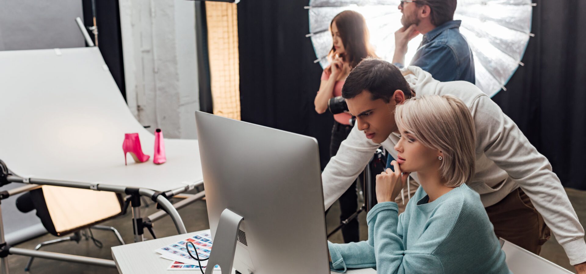 selective focus of coworkers looking at computer monitor in photo studio